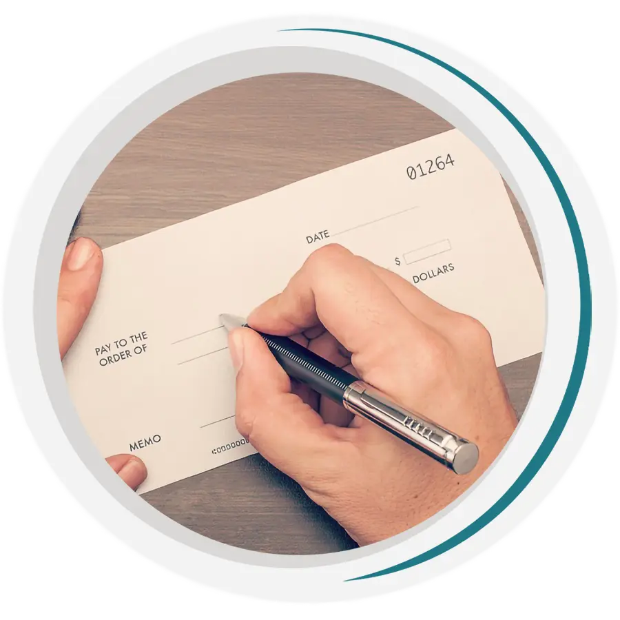 a close-up of a hand holding a pen, writing a check.