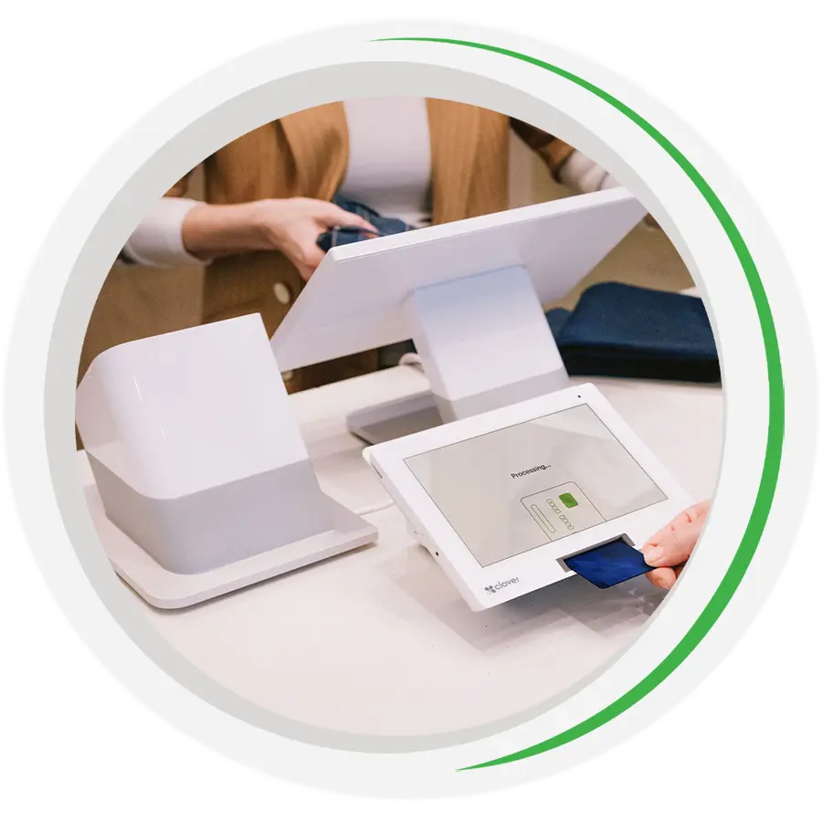 A customer dipping a credit card into the terminal of a Clover Station Duo POS system.