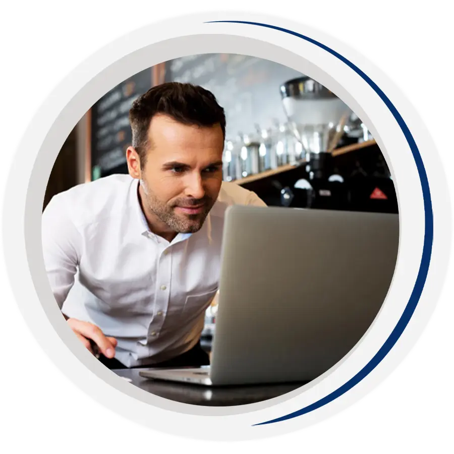 A cafe owner stares intently at his computer screen