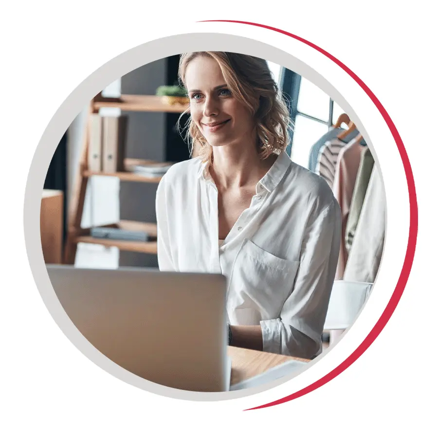 A woman in a retail shop works at her computer